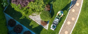 Drone shot of man mowing beautifully landscape serviced by Commercial Landscape Maintenance