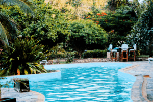 Enhance Your HOA's Outdoor Areas with Landscaping. Tropical resort-style swimming pool surrounded by lush greenery.
