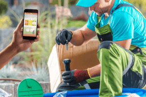 Landscape technician using smartphone app for irrigation system installation in a garden