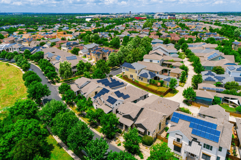 Aerial view of a suburban neighborhood with abundant trees, solar panels, and green spaces—demonstrating sustainable civic landscaping.