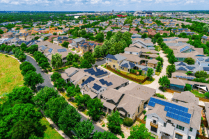 Aerial view of a suburban neighborhood with abundant trees, solar panels, and green spaces—demonstrating sustainable civic landscaping.
